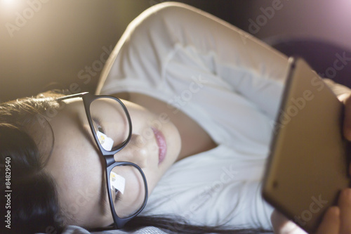 Woman using a tablet at bedroom