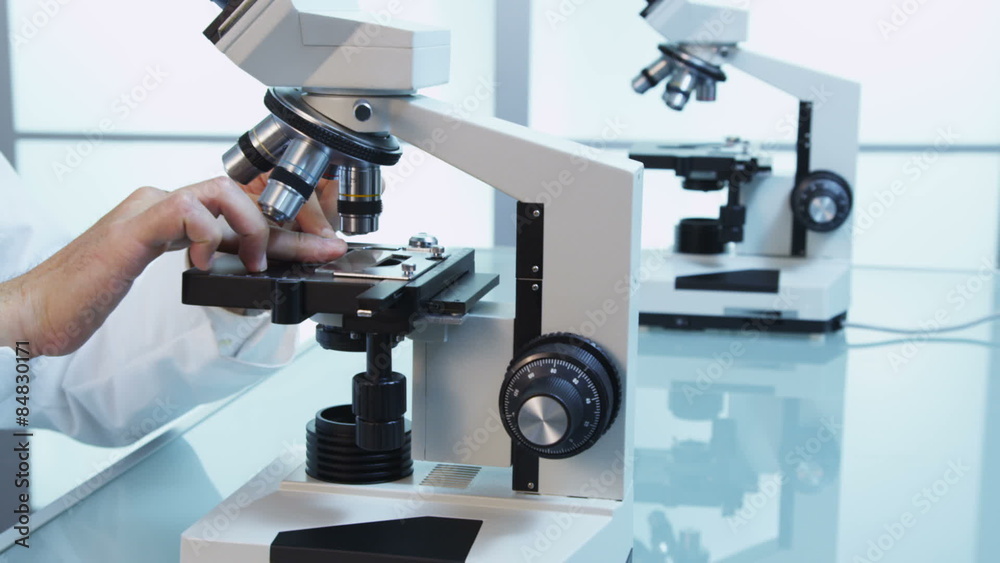 Scientist looks into microscope, dolly movement Scientist looks into microscope, dolly movement