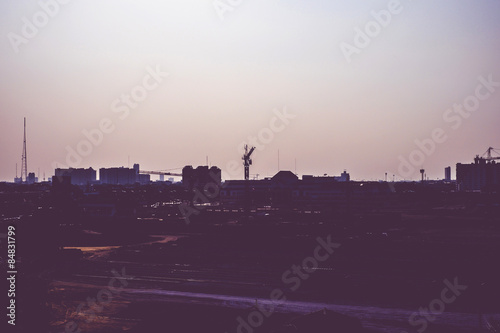 Vintage filter :Silhouette of landscape sunset scene with city b