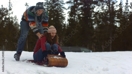 Couple sledding in the snow 