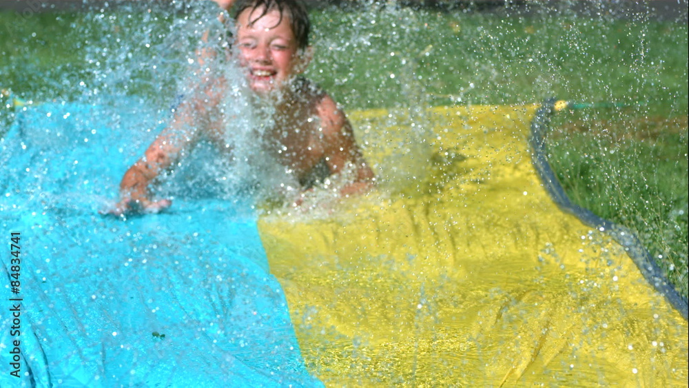 Young boy on water slide in slow motion