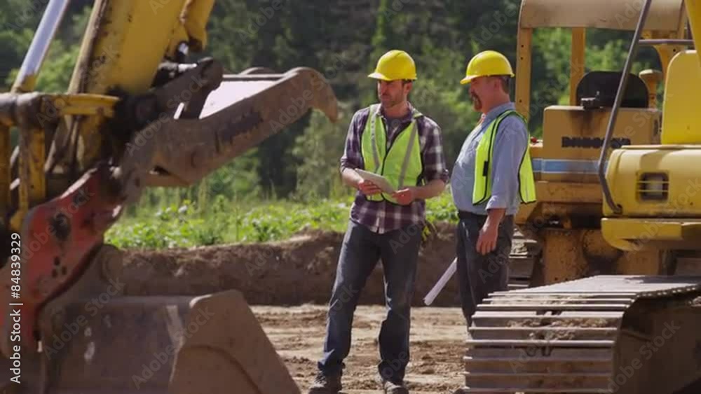 Two workers talking by machinery Two workers talking by machinery