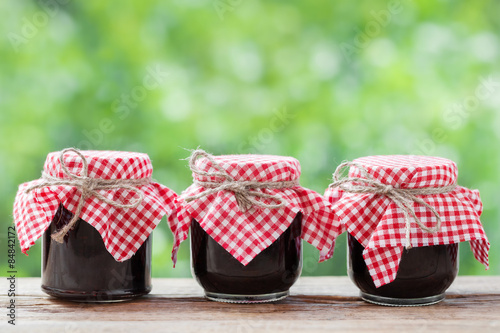 Three jears of jam on rustic table. photo