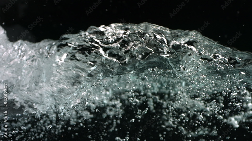 Bubbling water, black background, slow motion