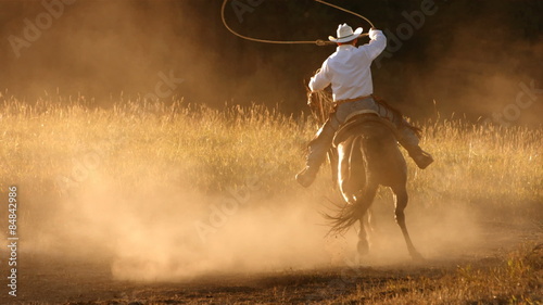 Cowboy roping at sunset, slow motion photo