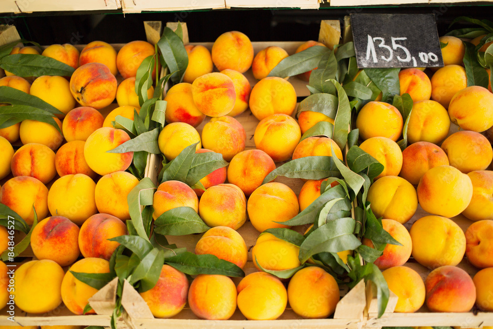 Fresh peaches arranged in row on farmers market