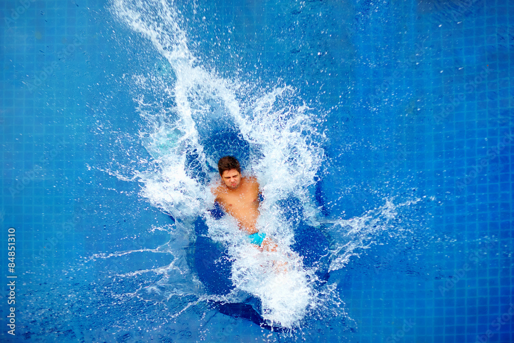 man jumping in pool, huge splash, top view