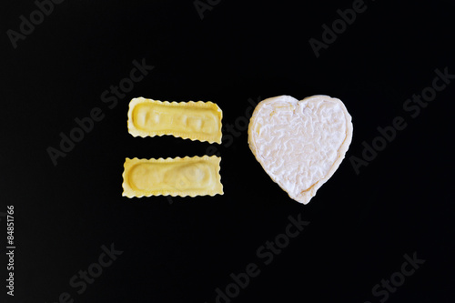 макаронные изделия в форме равенства и сыр в форме сердца на черном фоне photo