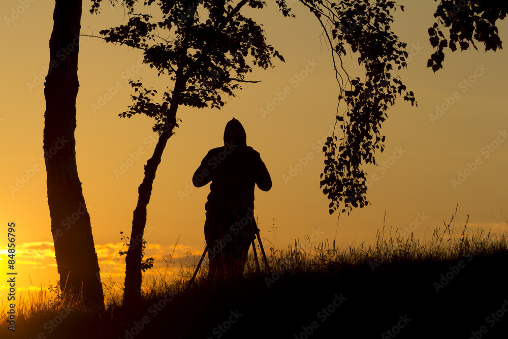Photographer in silhouette photographing the sunrise
