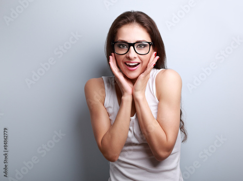 Excited surprising fun young woman with open mouth in glasses