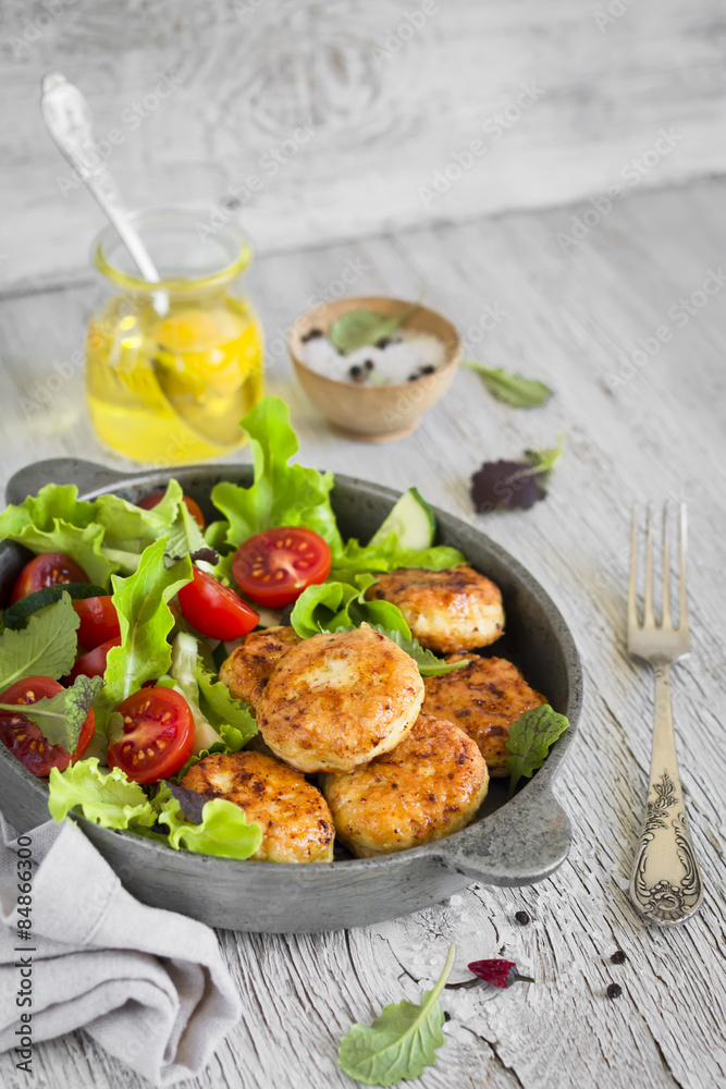 chicken cutlet with fresh vegetable salad in a vintage pan 