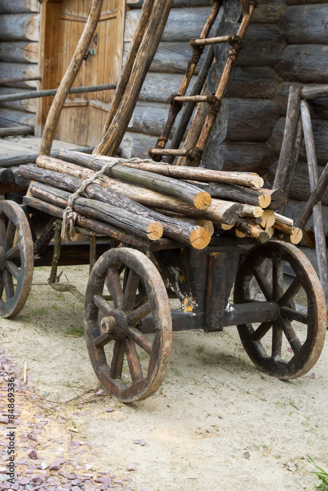 Old wooden cart with attached logs on it