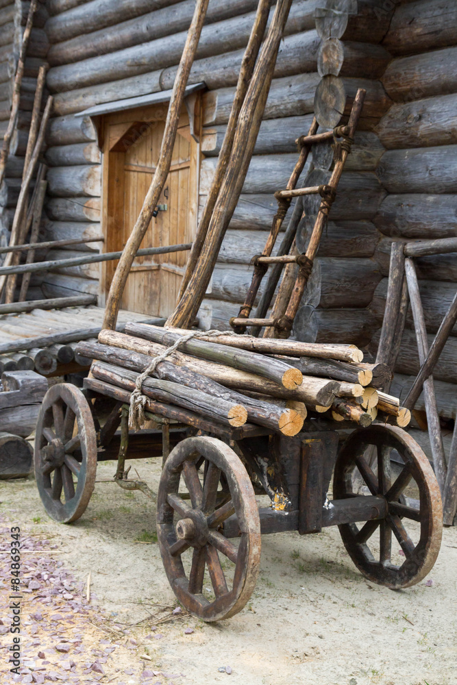 Old wooden cart with attached logs on it