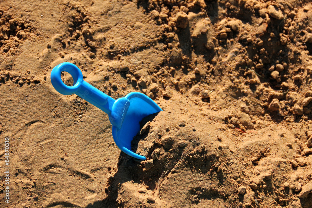 Blue childrens spatula, stuck in sand Blue childrens spatula, stuck in sand