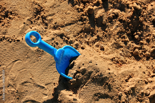 Blue childrens spatula, stuck in sand