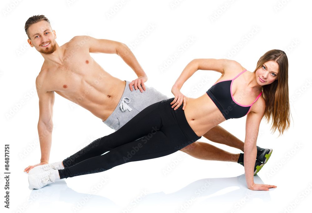 Attractive sport couple - man and woman doing fitness exercises