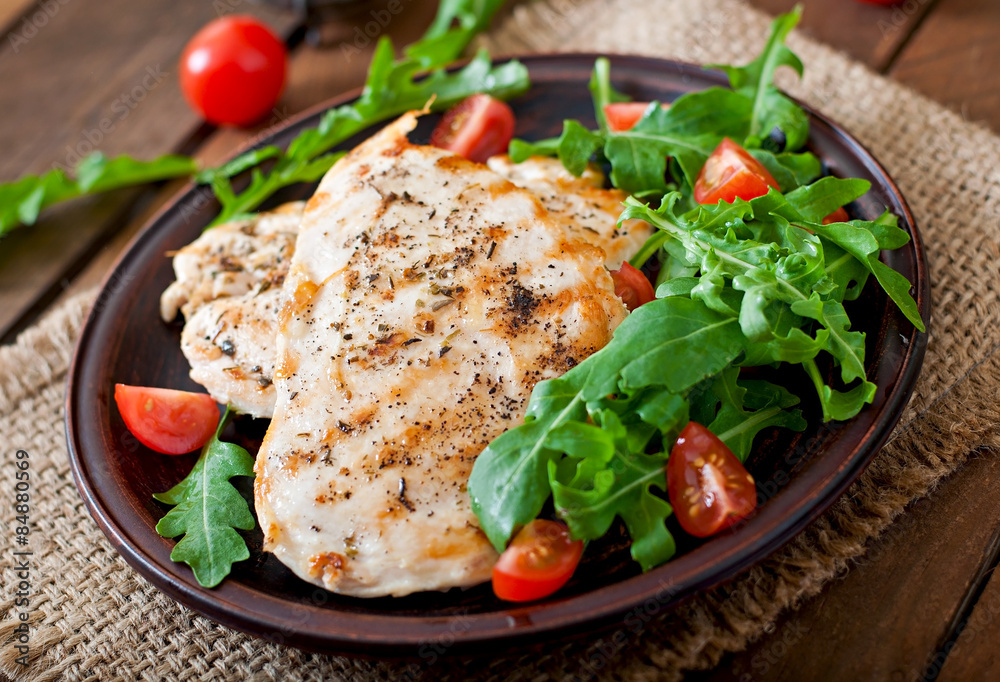 Chicken breast with fresh salad - arugula and tomato Chicken breast with fresh salad - arugula and tomato