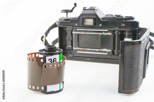 camera film and black camera with opened back lid on white background 