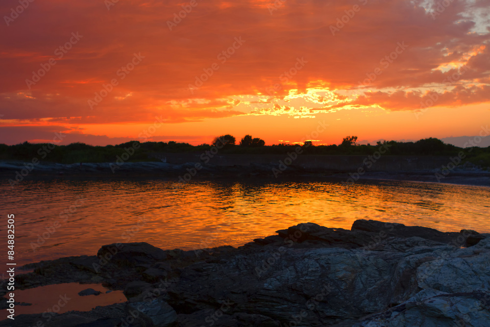 Obraz premium Sunset on a rocky shore.