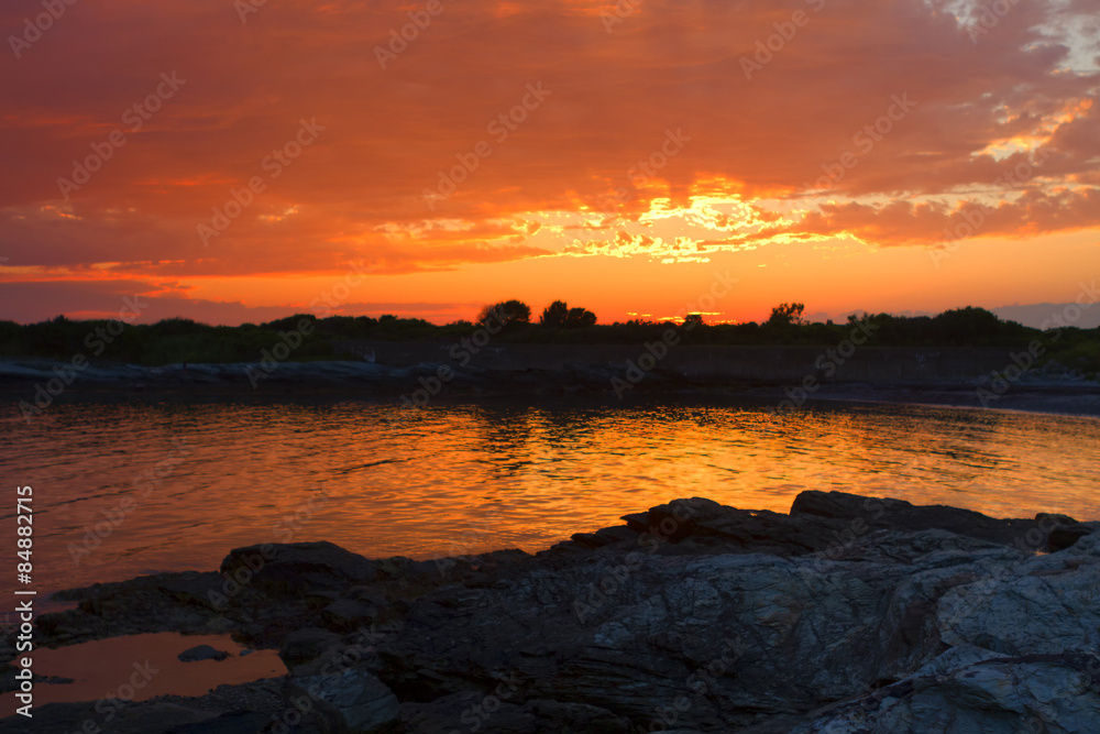 Obraz premium Sunset on a rocky shore.