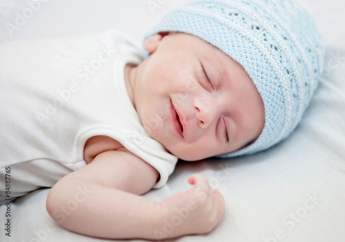 Baby with blue cap sleeping peacefully