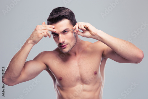 Canvastavla Man removing eyebrow hairs with tweezing