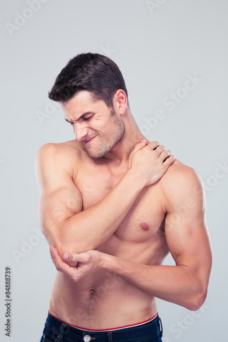 Muscular man holding his elbow in pain