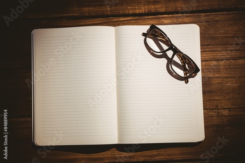 Empty notepad with reading glasses