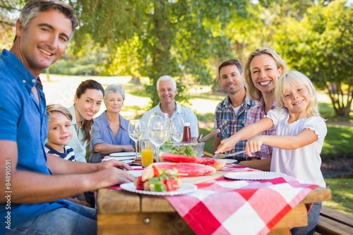 Happy family having picnic and holding american flag