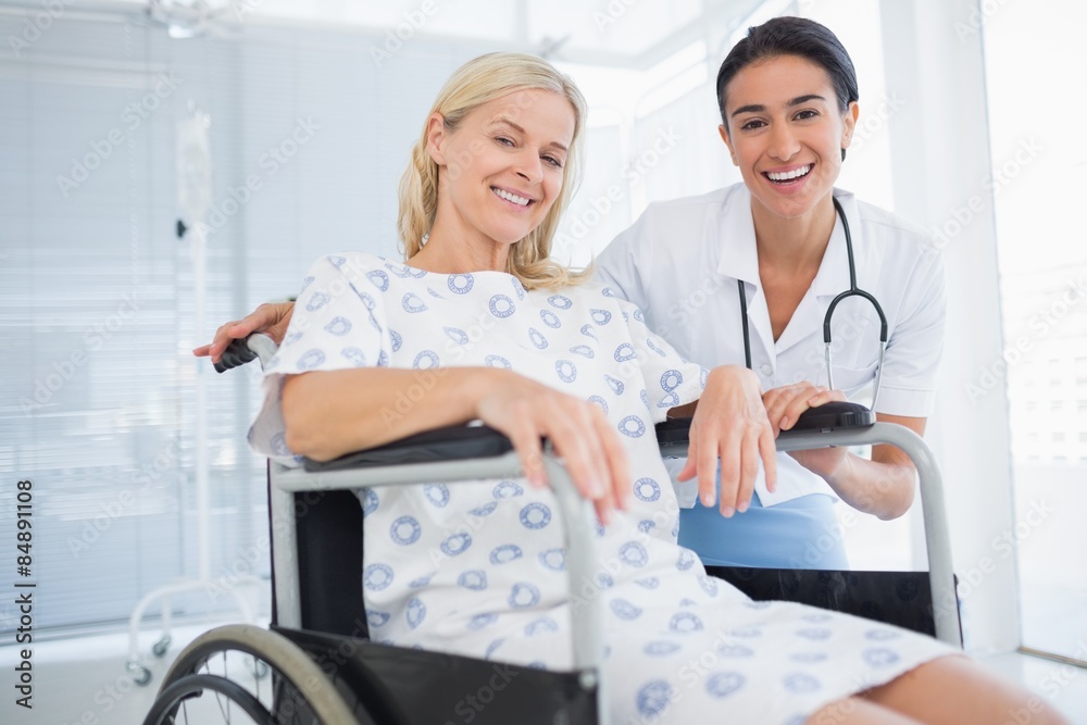 Doctor and patient in wheelchair smiling at camera Doctor and patient in wheelchair smiling at camera