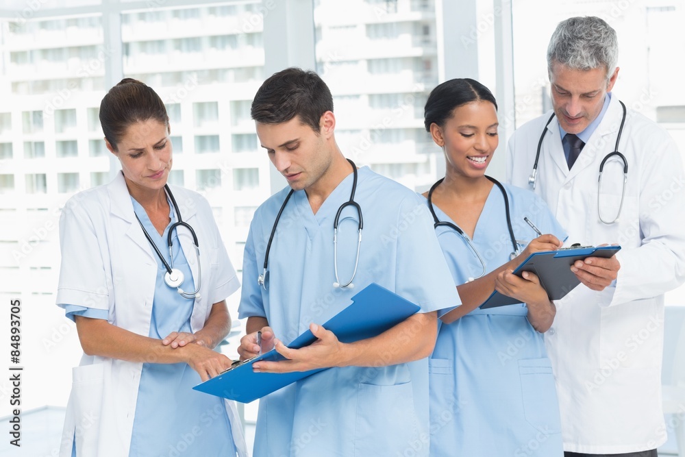 Male and female doctors working on reports Male and female doctors working on reports