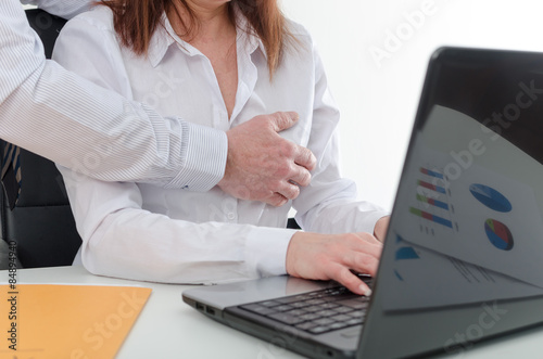 Manager putting his hand on the breast of his secretary