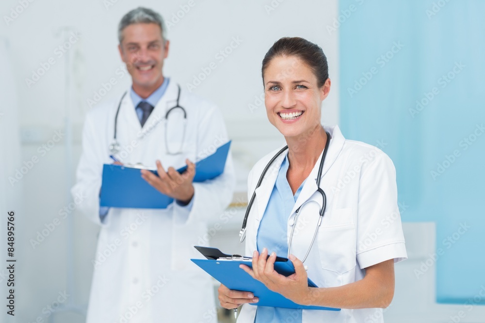 Male and female doctors working on reports Male and female doctors working on reports