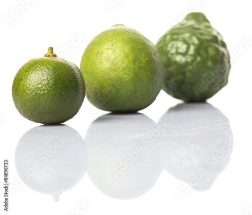 Lime, makrut or kaffir lime and calamansi over white background photo