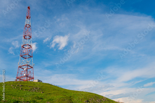 Telecommunications tower over blue sky background.