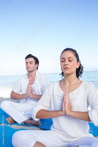 Happy couple doing yoga beside the water © WavebreakmediaMicro