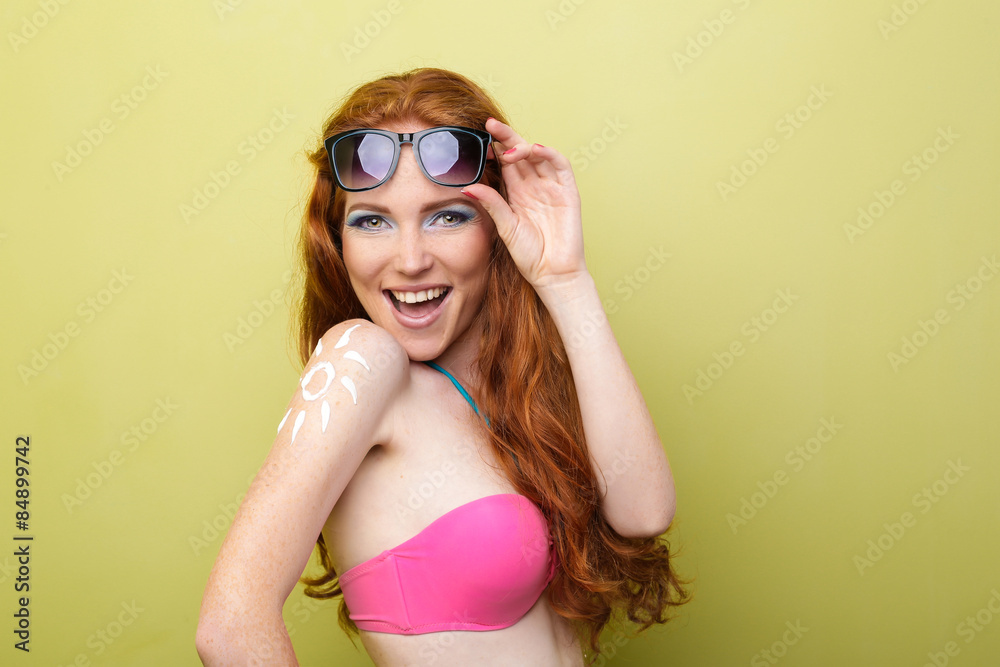 Funny woman applying sunscreen or suntan lotion on her shoulder Funny woman applying sunscreen or suntan lotion on her shoulder