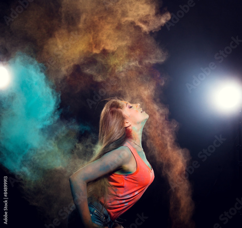 girl with colored powder exploding around her and into the background © selenit