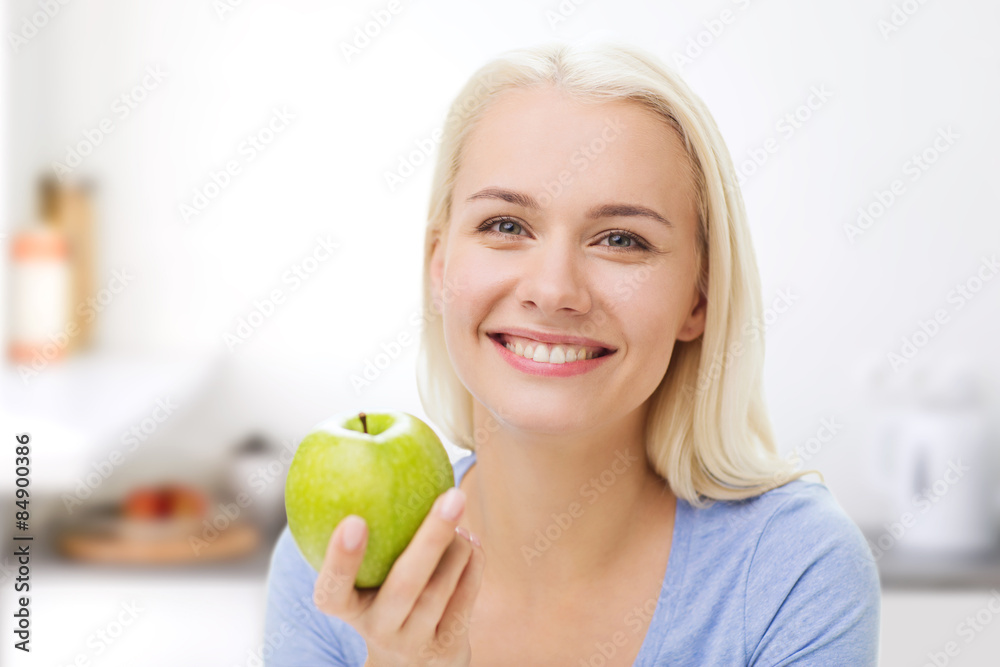 happy woman eating green apple on kitchen happy woman eating green apple on kitchen