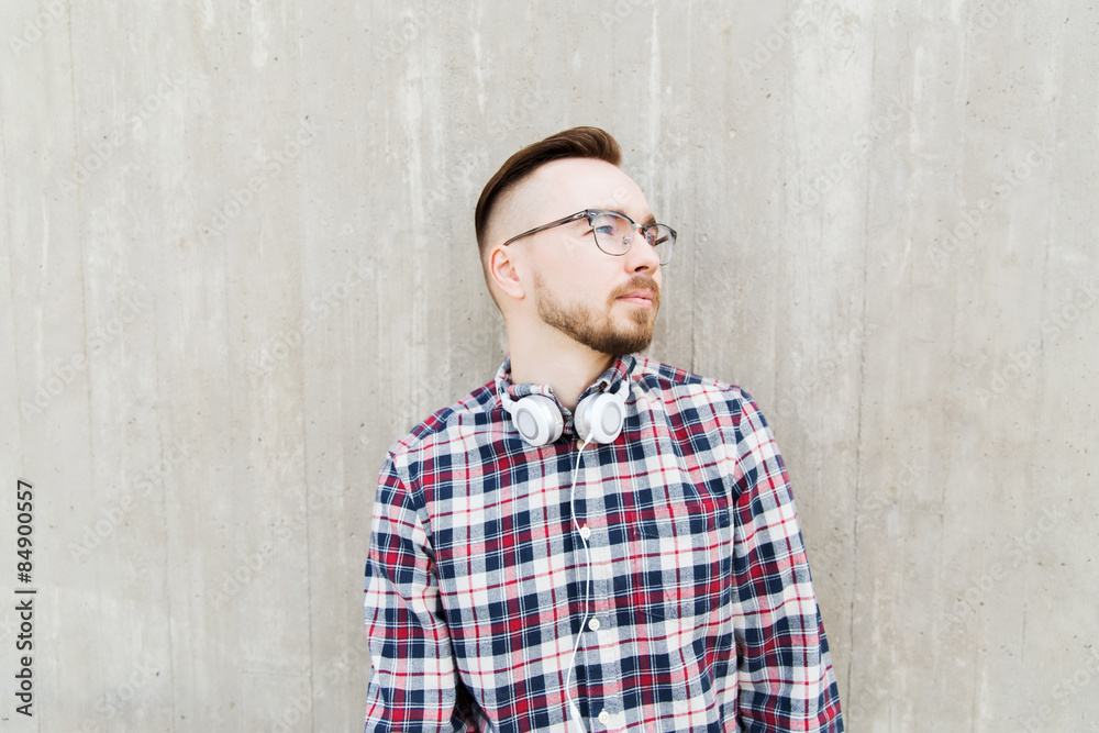 happy young hipster man with headphones over wall