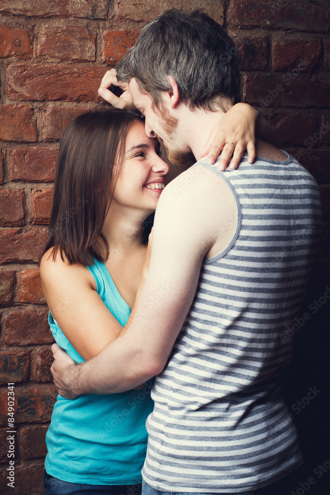 happy couple against a brick wall happy couple against a brick wall