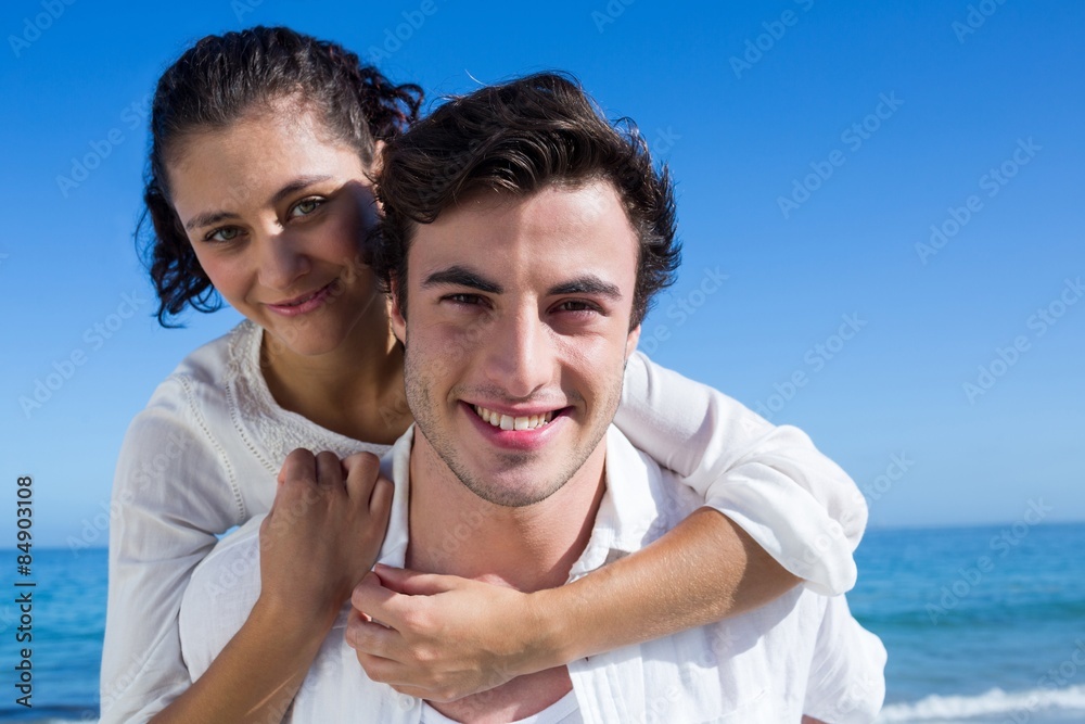 Handsome man giving piggy back to his girlfriend Handsome man giving piggy back to his girlfriend
