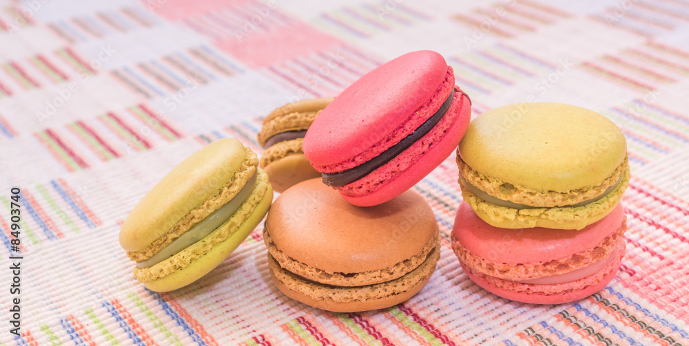 Fototapeta premium Sweet and colourful french macaroons on cotton cloth background.