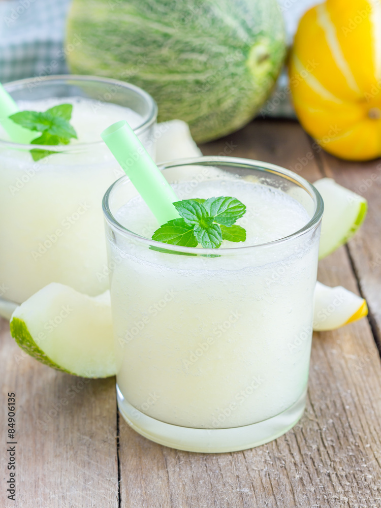 Fresh melon smoothie in the glass on the wooden table Fresh melon smoothie in the glass on the wooden table