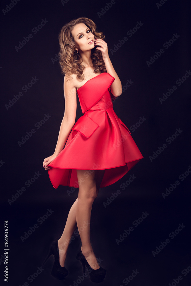 Fashion studio shot of beautiful woman with makeup and hairstyle wearing evening dress Fashion studio shot of beautiful woman with makeup and hairstyle wearing evening dress