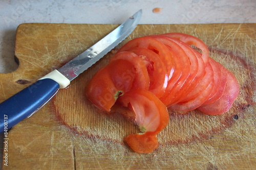 Tomato cut with a knife on the kitchen blackboard