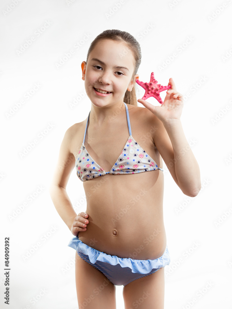 happy girl in swimming suit showing red starfish happy girl in swimming suit showing red starfish