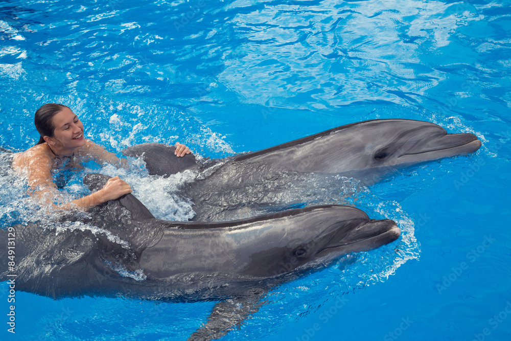 Obraz premium Girl swimming with Dolphin