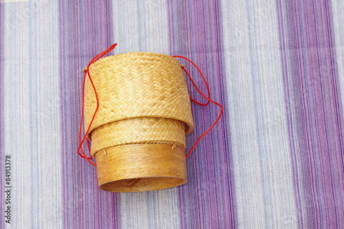 Kratip, thai bamboo sticky rice container on loincloth fabric background