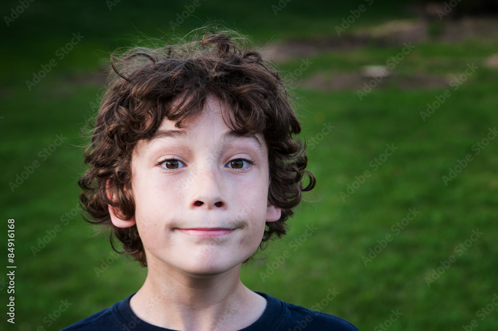 young brown haired boy outdoors on a green grassy yard young brown haired boy outdoors on a green grassy yard